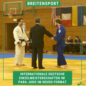 Zwei Judoka stehen sich gegenüber, in der Mitte steht ein Schiedsrichter im Anzug. 